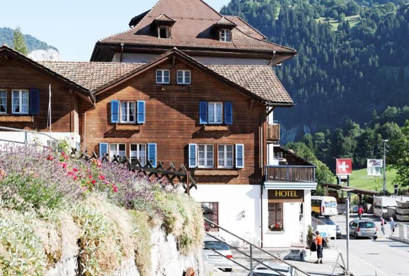 un gran edificio de madera en un lateral de una montaña en Ferienwohnung Bahnhöfli, en Lauterbrunnen