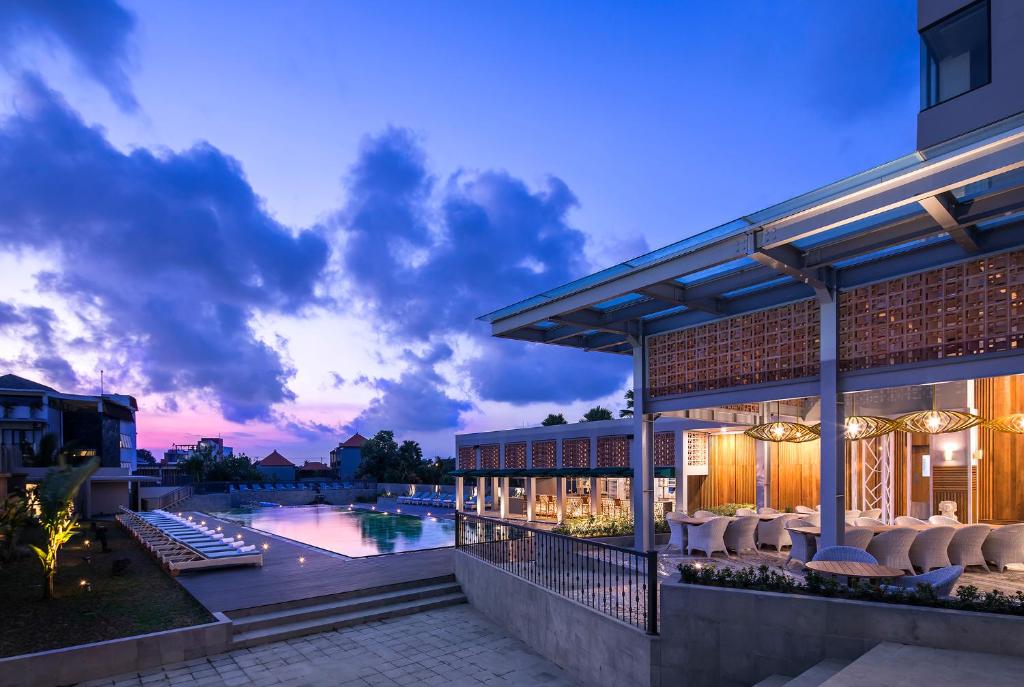 an exterior view of a building with a swimming pool at Eastin Ashta Resort Canggu in Canggu