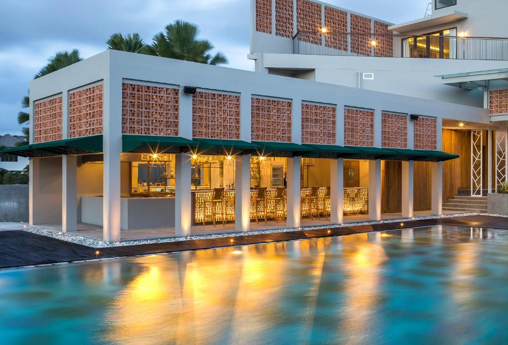 a hotel with a swimming pool in front of a building at Eastin Ashta Resort Canggu in Canggu