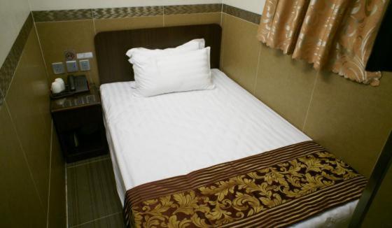 Rúm í herbergi á B&B Mongkok Hotel