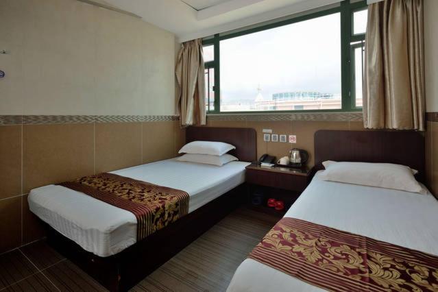 Rúm í herbergi á B&B Mongkok Hotel