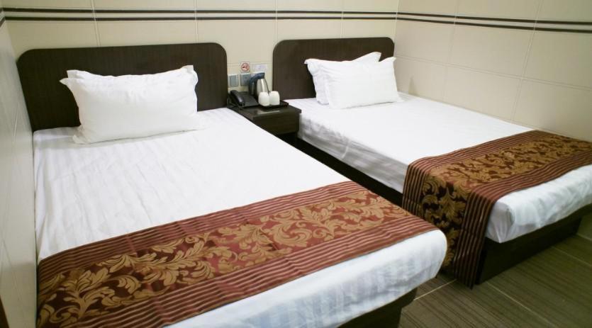 2 camas en una habitación de hotel con sábanas blancas en B&B Mongkok Hotel, en Hong Kong