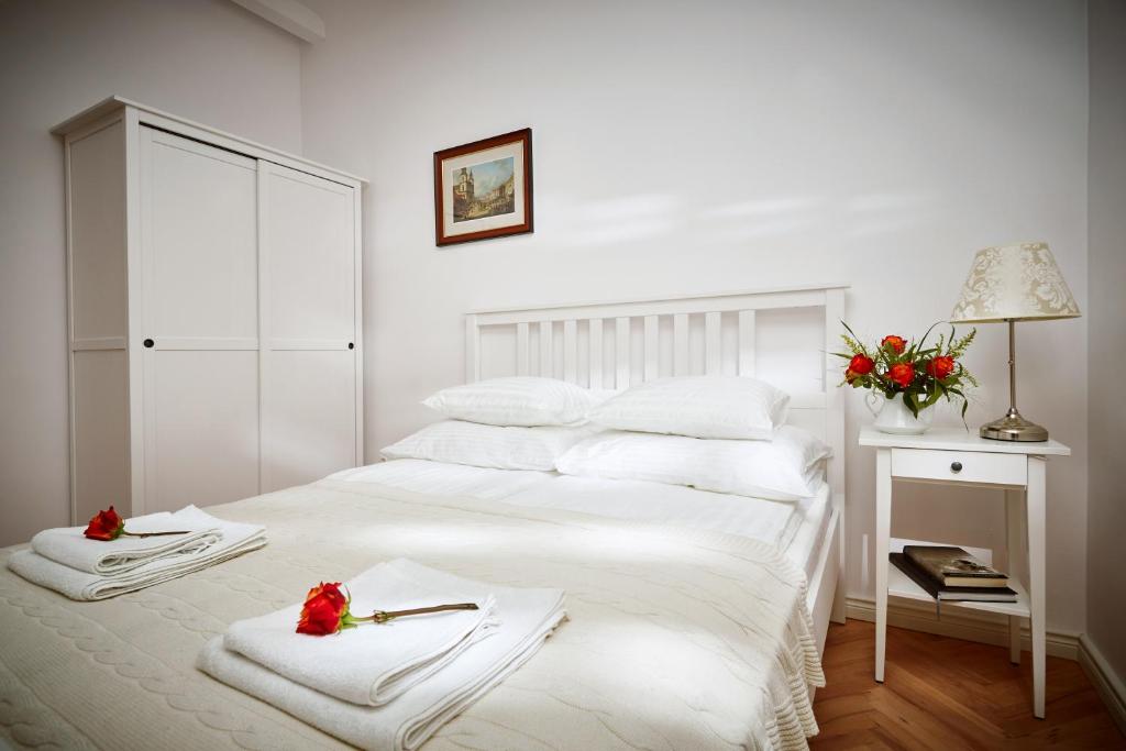 Un dormitorio blanco con una cama con toallas. en Mariensztat / Old Town Place for You, en Varsovia