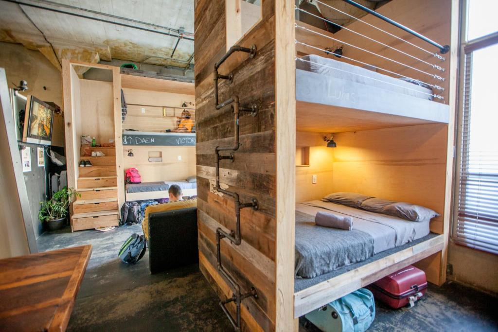 a bedroom with a bunk bed with a wooden wall at PodShare Hollywood in Los Angeles