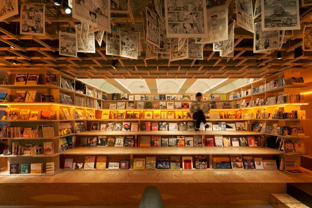 una librería con libros en estanterías en una habitación en Book And Bed Tokyo Shinjuku, en Tokio