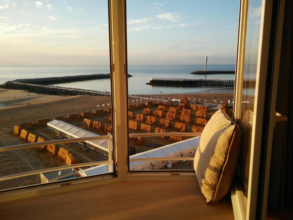 a room with a window with a view of a beach at Appartement met Zeezicht in Ostend