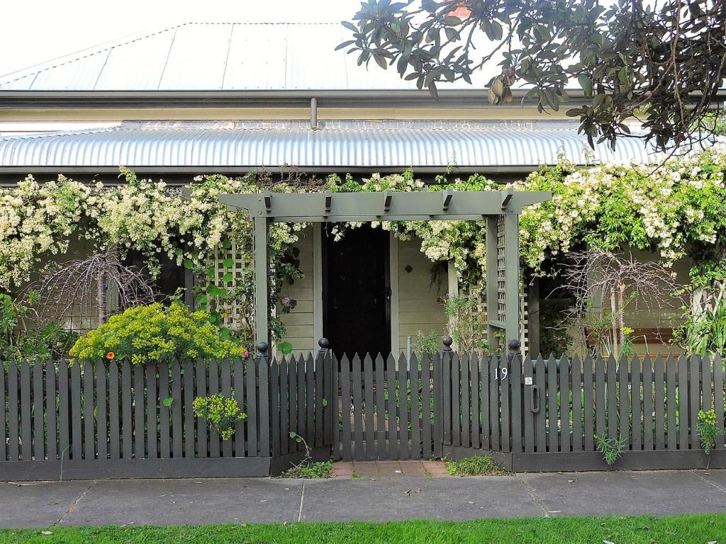 a house with a fence in front of it at Delightful Cottage in Queenscliff