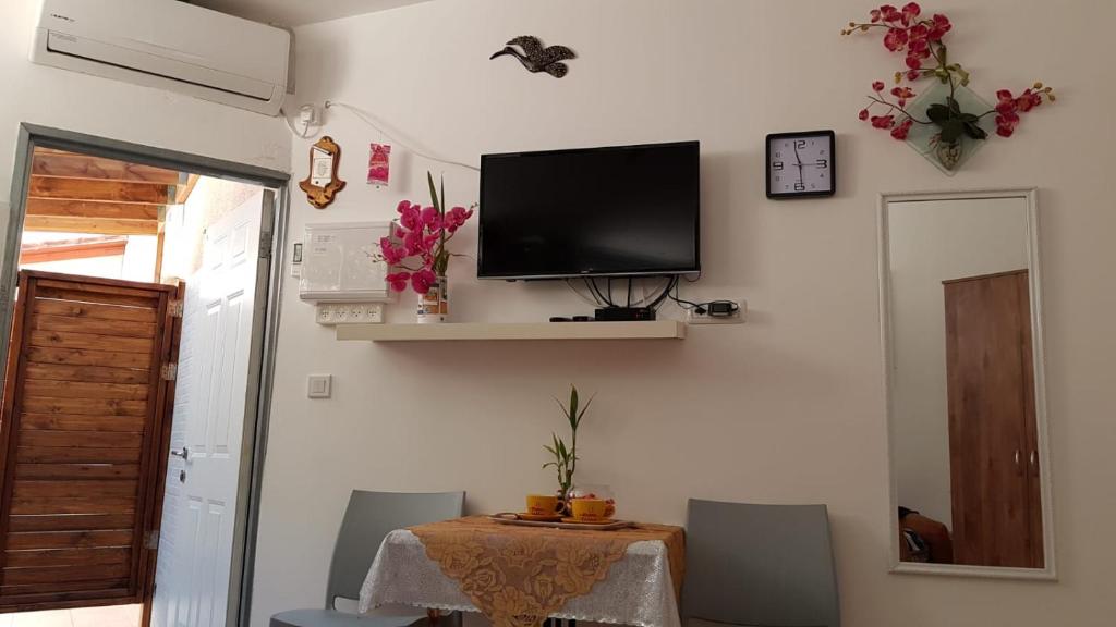 ein Esszimmer mit einem Tisch und einem TV an der Wand in der Unterkunft The Taras unit in Eilat