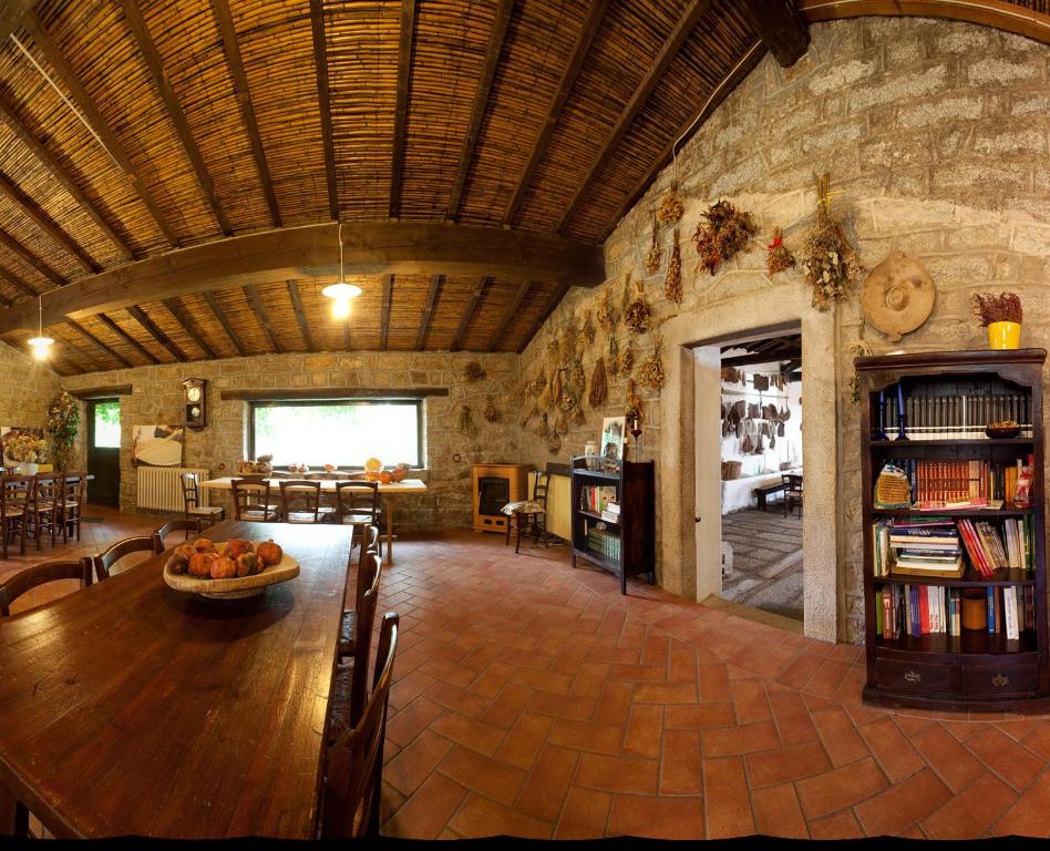 a large room with a stone building with a table and chairs at Agriturismo Testone in Benetutti
