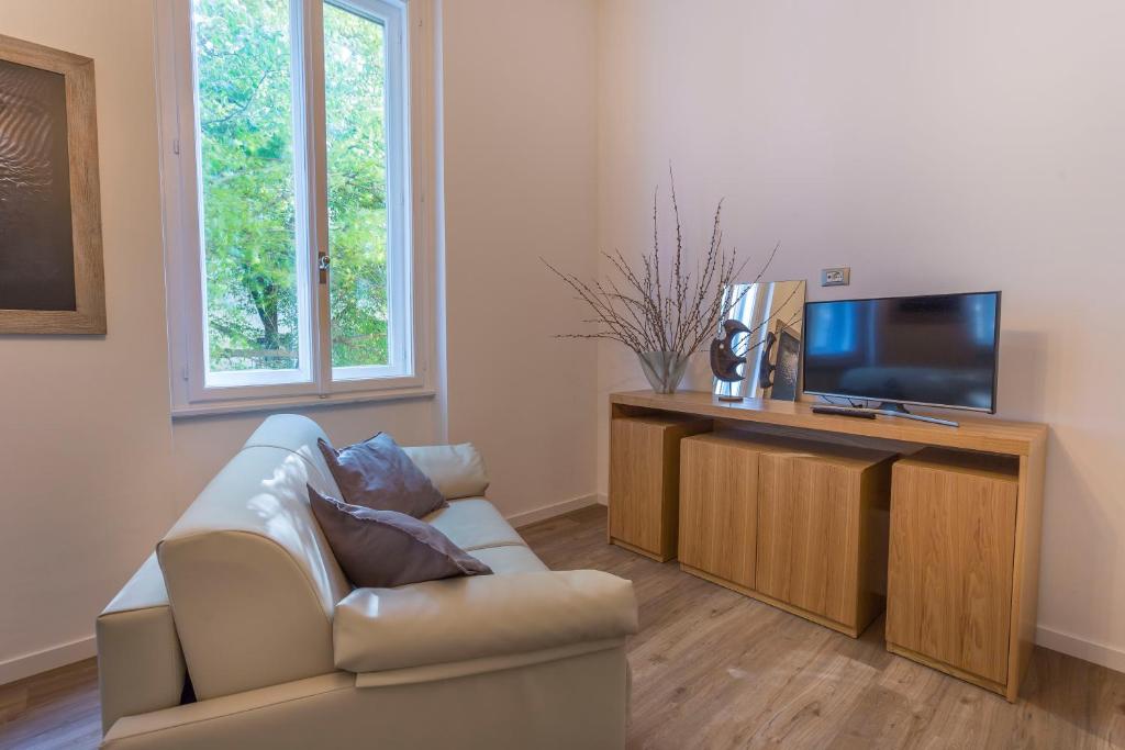 a living room with a couch and a flat screen tv at Udine Centre Stylish Apartment in Udine