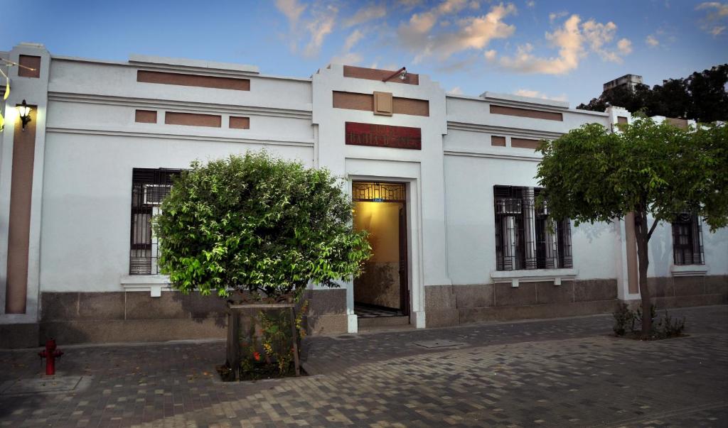 ein weißes Gebäude mit einer Tür und einem Baum in der Unterkunft Hotel Bahia Blanca in Santa Marta