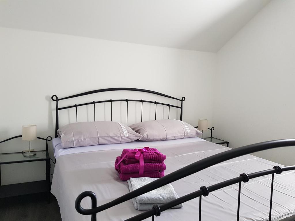 ein Schlafzimmer mit einem Bett mit einer rosa Tasche darauf in der Unterkunft Apartments Krizanac in Trogir