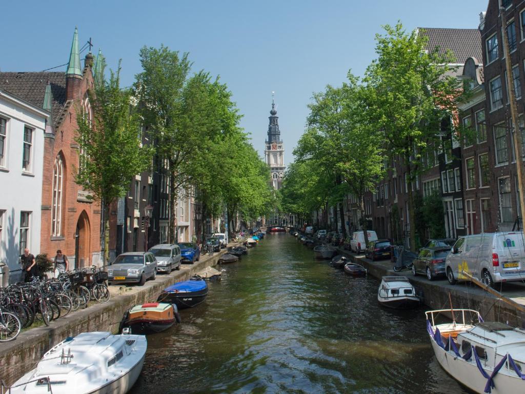 a canal with boats parked on the sides and buildings at Rembrandtplein Hotel in Amsterdam