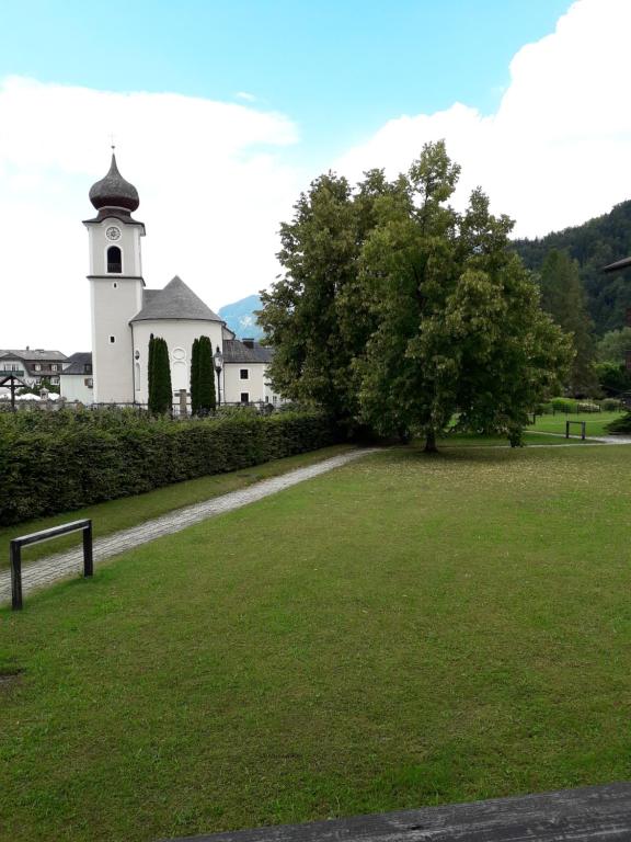 シュトローブルにあるAppartment "Am Hasenanger"の畑の前に木が植えられた教会