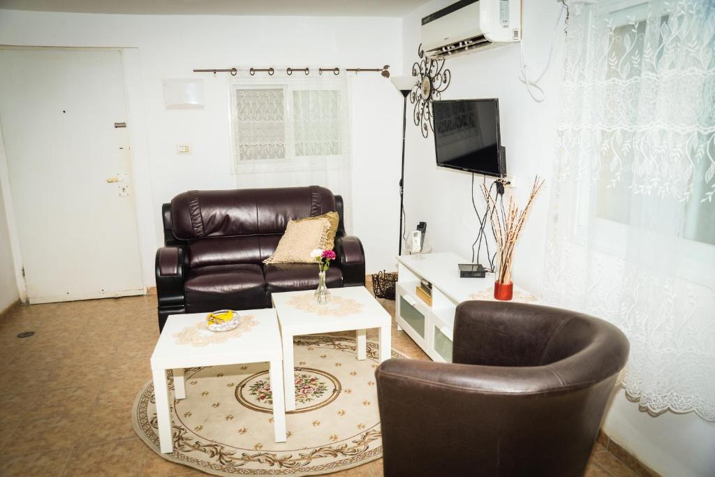 Master hosting Gal في بيسان: غرفة معيشة مع كرسي جلدي وطاولة