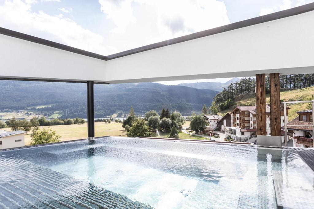 uma piscina com vista para as montanhas em Aktiv- und Wellnesshotel Traube- Post em Curon Venosta