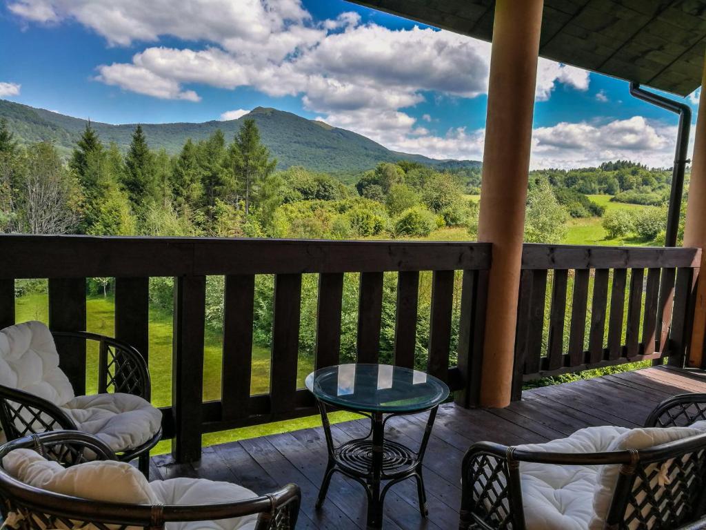 a deck with chairs and tables and a view of the mountains at Dwór Roh in Wetlina