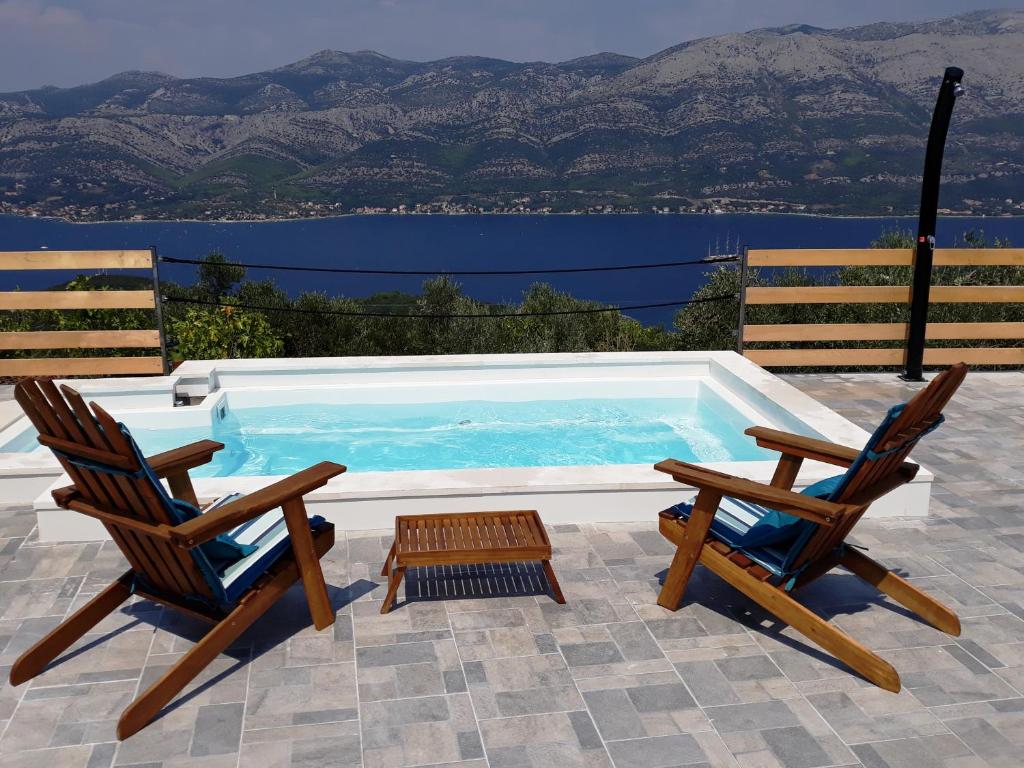 two chairs and a pool with a view of the water at BELLAVISTA Luxury Lodge in Korčula