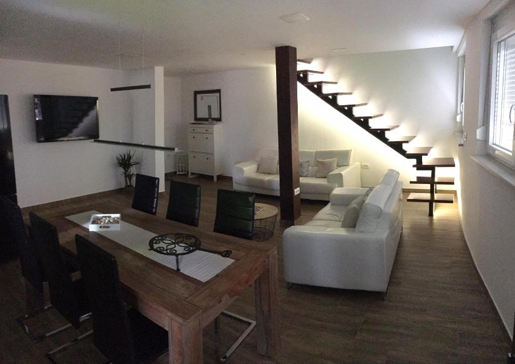 un soggiorno con divano bianco e scala di Apartment Ida a Capodistria