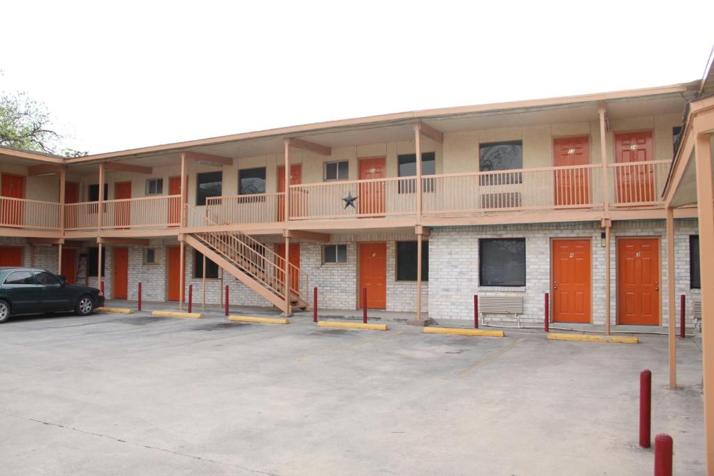 budynek z pomarańczowymi drzwiami i parkingiem w obiekcie Choice Inn San Antonio w mieście San Antonio