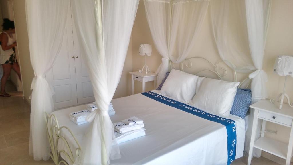 マニルバにあるMarina de la Duquesa Apartmentのベッドルーム(白いカーテン付きの白いベッド1台付)