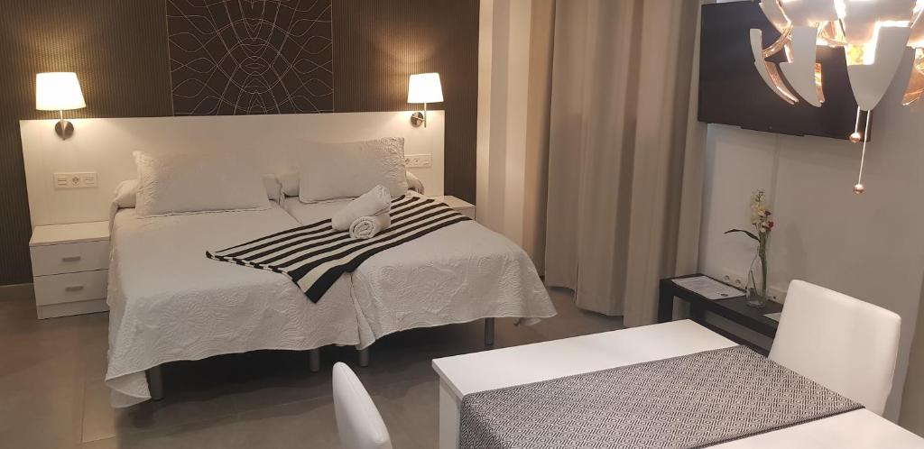 - une chambre avec un lit, une table et des chaises dans l'établissement Nest Flats Granada, à Grenade