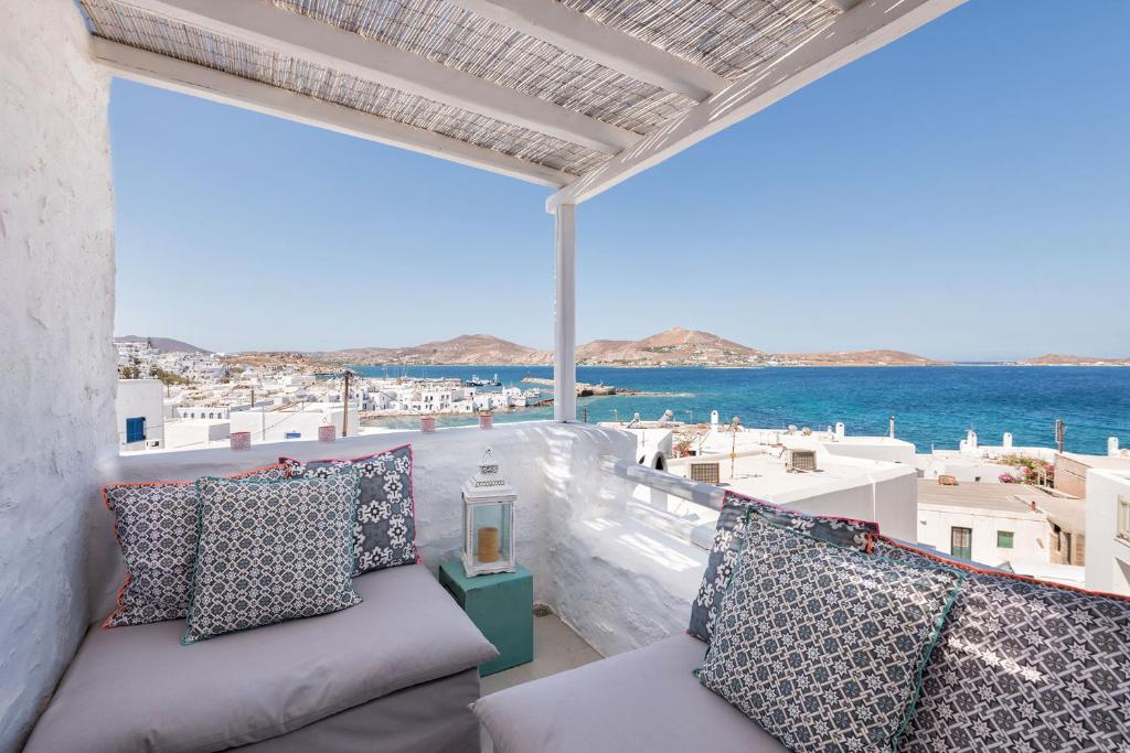 balcón con sofá y vistas al océano en Asimi House, en Naousa