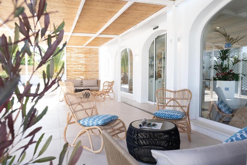 a porch with wicker chairs and a table at FERGUS Style Carema Beach in Cala en Bosc