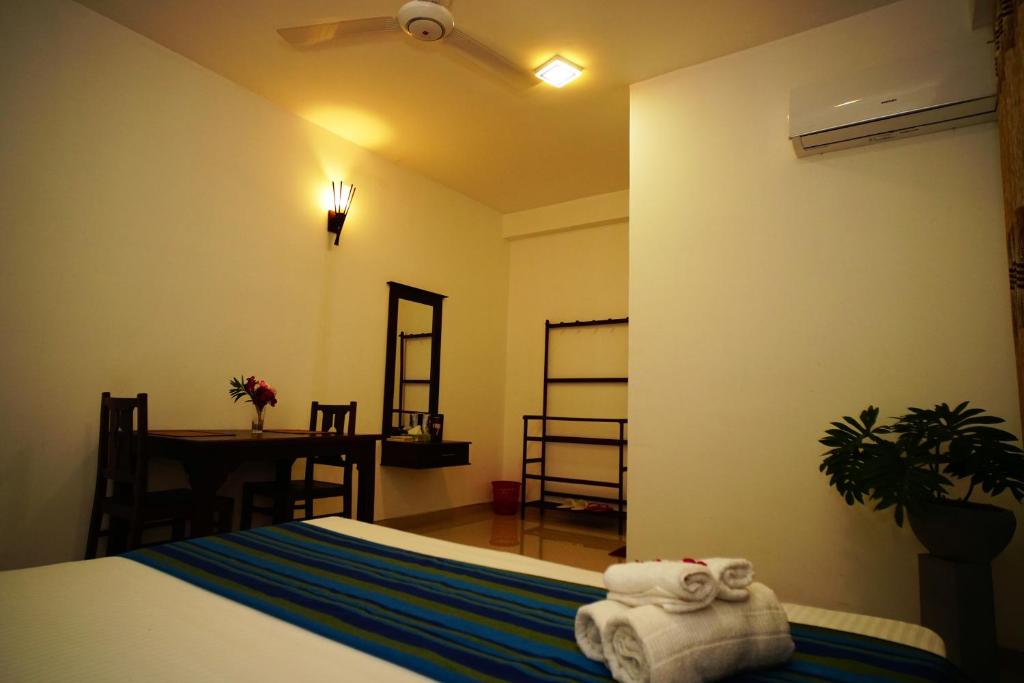 een slaapkamer met een bed en een tafel met handdoeken bij Airport 4 Season Transit Hotel in Katunayaka