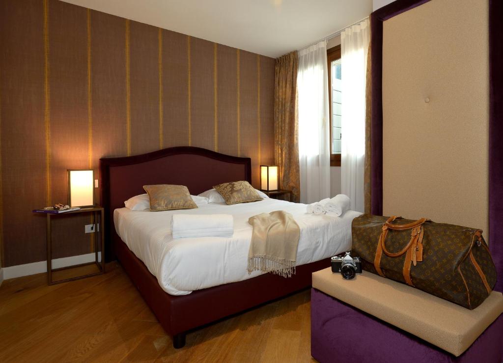 a hotel room with a large bed and a window at Residence La Fenice in Venice