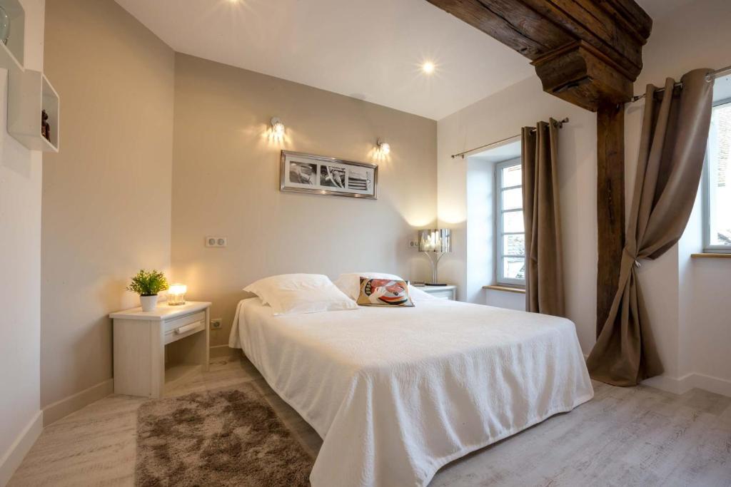 a bedroom with a white bed and a window at Beaune Sweet Home in Beaune