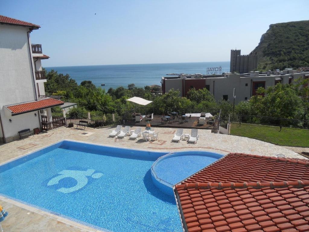 una piscina con sillas y vistas al océano en Kavarna Paradise Apartments en Kavarna