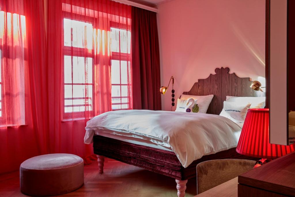 a bedroom with a large bed and a large window at 25hours Hotel The Royal Bavarian in Munich