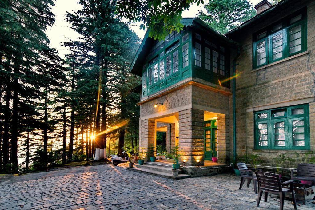 a house with a stone patio in front of it at Brij Villa, Dalhousie - A Colonial Luxury Retreat in Dalhousie