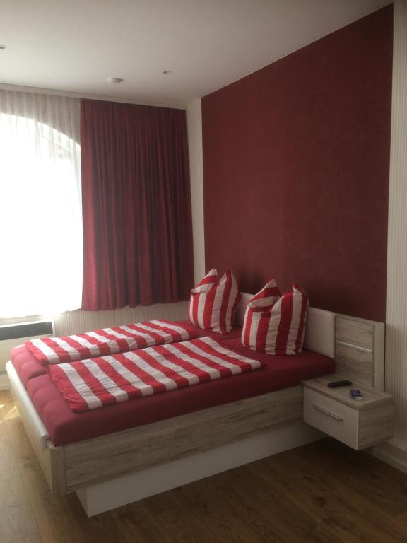 Eisenach - Apartments في إيزيناخ: غرفة نوم بسرير ومخدات مخططة حمراء وبيضاء