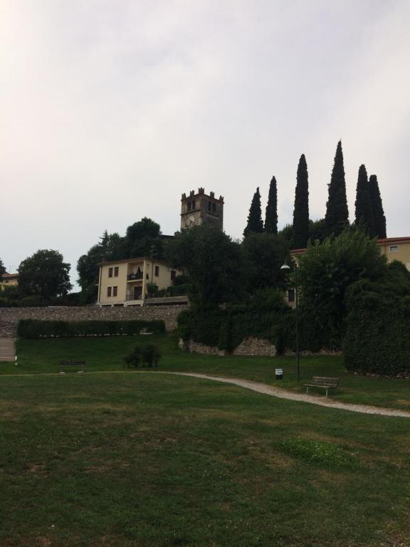 un parque con un edificio y un castillo en la distancia en Locazione turistica Isabella en Castelnuovo del Garda