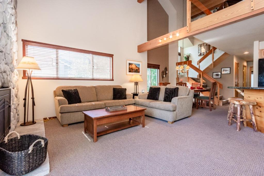 ein Wohnzimmer mit 2 Sofas und einem Tisch in der Unterkunft Snowcreek 598 in Mammoth Lakes