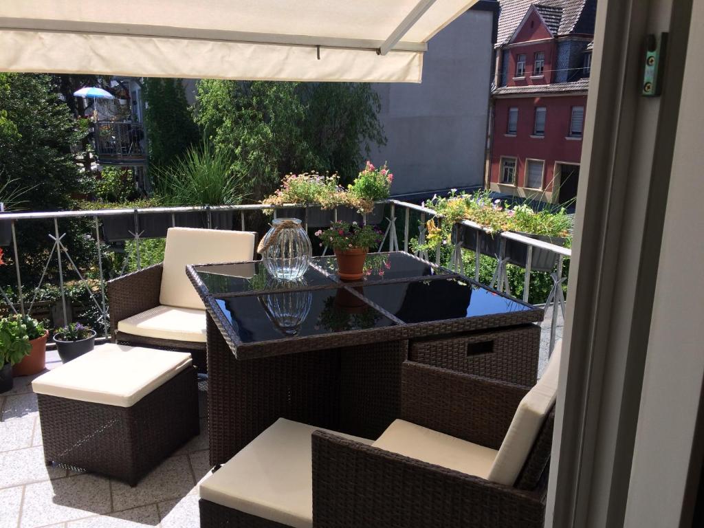 einen Balkon mit einem Tisch, Stühlen und einem Sonnenschirm in der Unterkunft Apartment Troisdorf - Bonn in Troisdorf