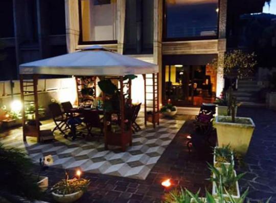 a patio with a table and a large umbrella at Villa Angela in San Benedetto del Tronto