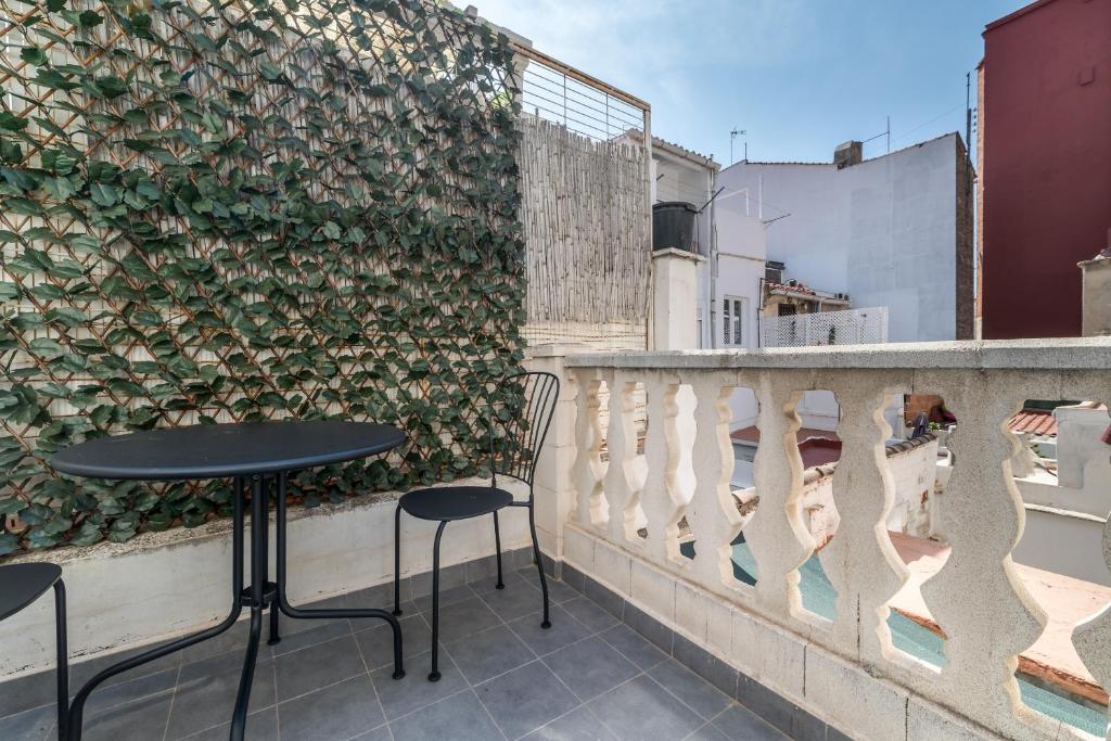 バレンシアにあるTravel Habitat Cabanyalの緑の壁のバルコニーにテーブル