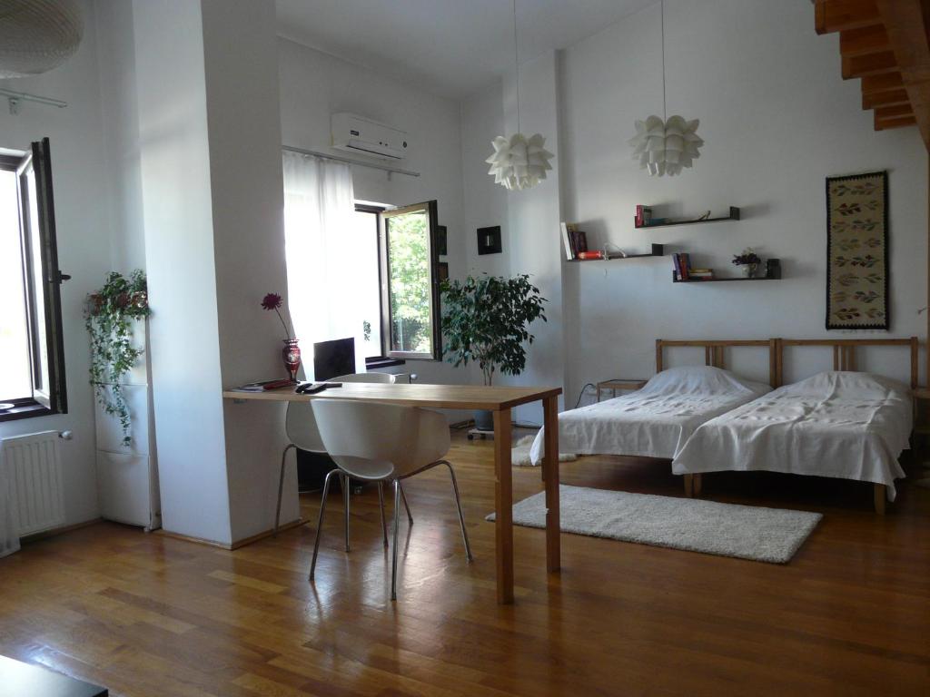 uma sala de estar com uma mesa e uma cama em Cosy studio 55sqm, Cotroceni Area em Bucareste
