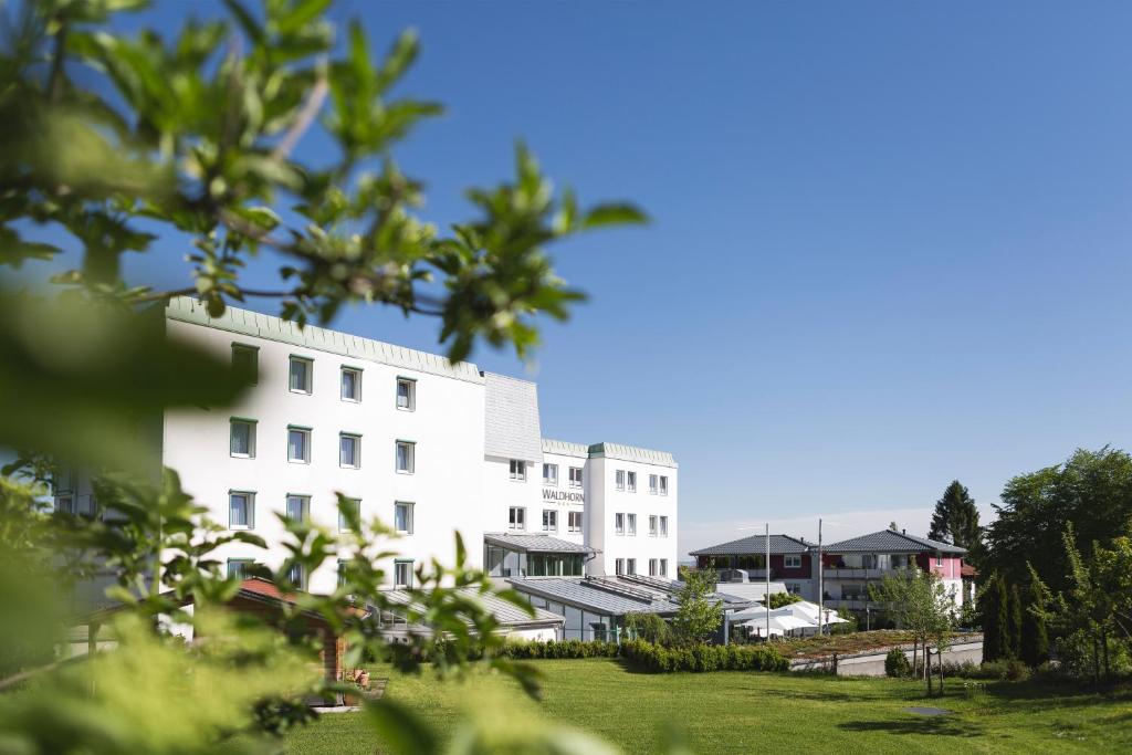 ein weißes Gebäude mit Bäumen davor in der Unterkunft Hotel Waldhorn in Kempten