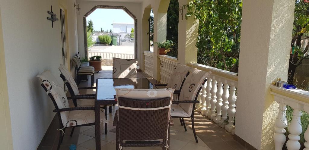 a porch with chairs and a table and a window at Apartmani Gabi in Cesarica
