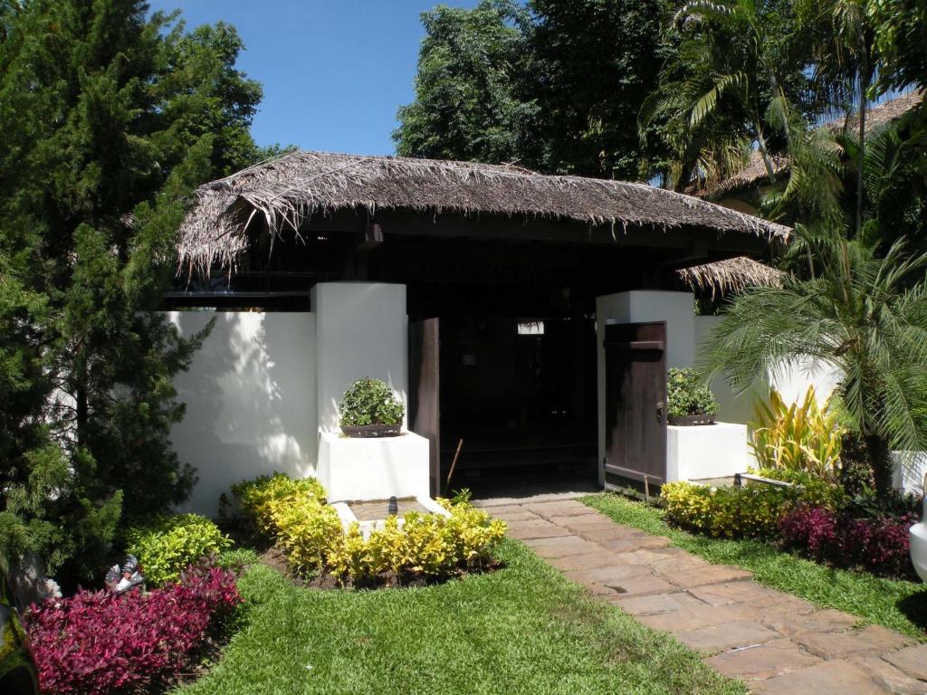 un piccolo edificio con tetto di paglia di Ploy Resort a Kanchanaburi