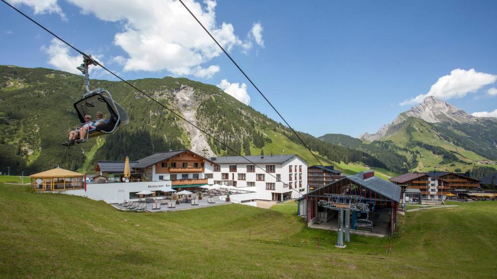 a person riding a ski lift in the mountains at Hotel Steffisalp in Warth am Arlberg