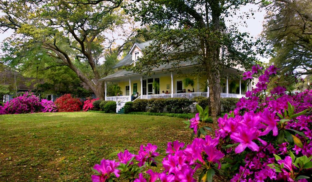 una casa con fiori rosa nel cortile di Magnolia Springs Bed and Breakfast a Magnolia Springs
