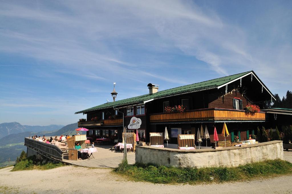 um edifício com mesas e cadeiras em frente em Angerer Alm em Sankt Johann in Tirol