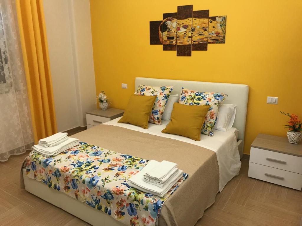 a bedroom with a bed and a yellow wall at Holiday In Home | Le Ciminiere in Catania