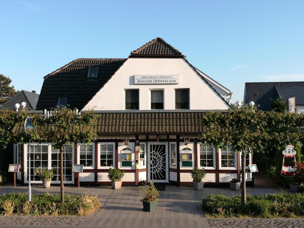 a large white building with a black roof at Zingster Ostseeklause in Zingst