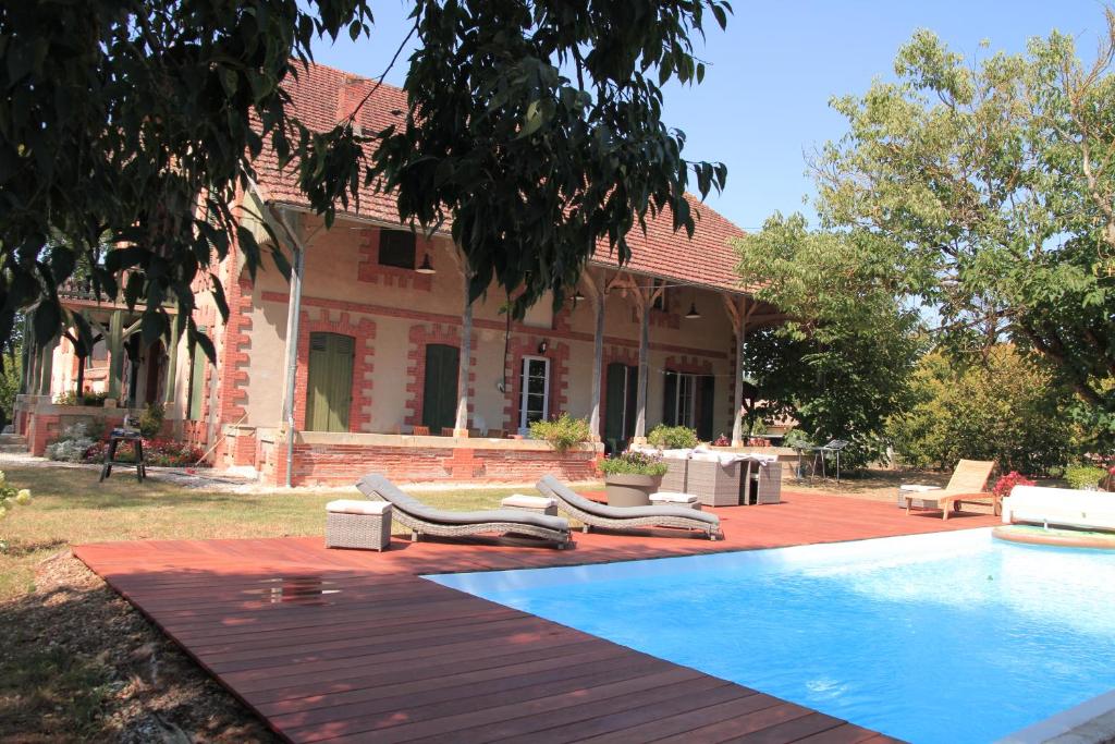 ein Haus mit einem Pool vor einem Haus in der Unterkunft Gîte la Prunéloise in Lafitte-sur-Lot